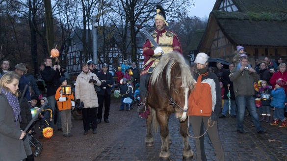 Traditioneller Sankt-Martinsumzug mit Reiter und Kinder mit selbstgemachten Laternen