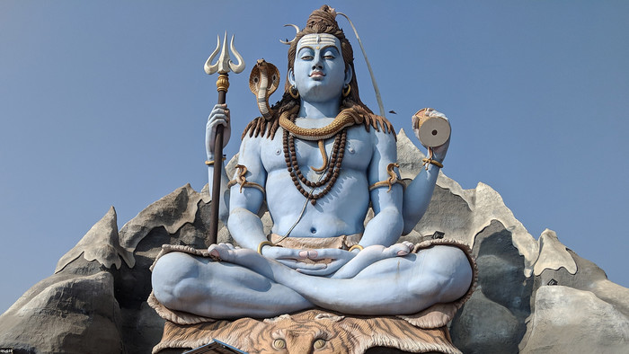 Statue des Hindu-Gottes Vishnu mit prächtigem Goldschmuck auf dem Kopf und um den Hals.
