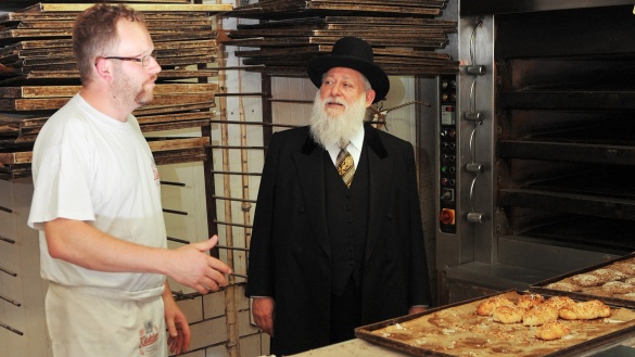 Ein Bäckermeister und ein orthodoxer Jude mit einer Kiste Brot.