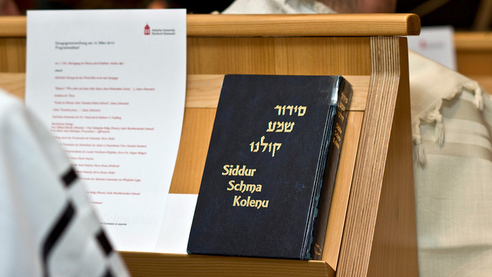 Das jüdische Gebetbuch, Siddur, steht in einer Synagoge
