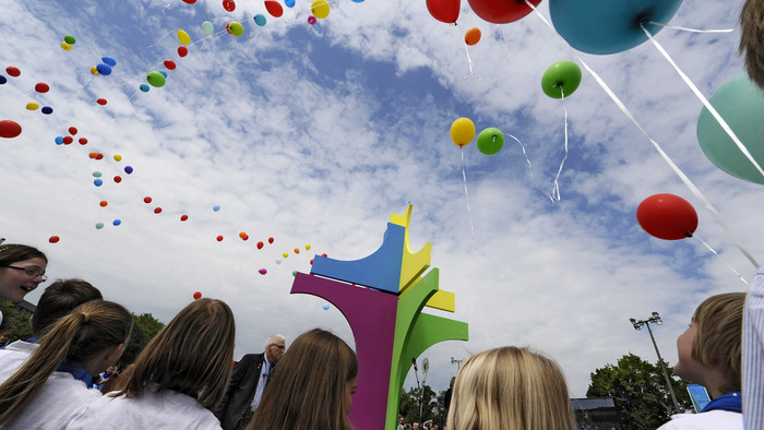 Kinder lassen beim Abschlussgottesdienst des Katholikentages 2014 in Regensburg 100 bunte Luftballons rund um ein großes, mehrfahrbiges Kreuz in den Himmel steigen.