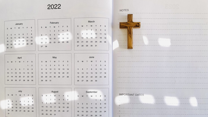 Stillleben mit Kalender und Holzkreuz
