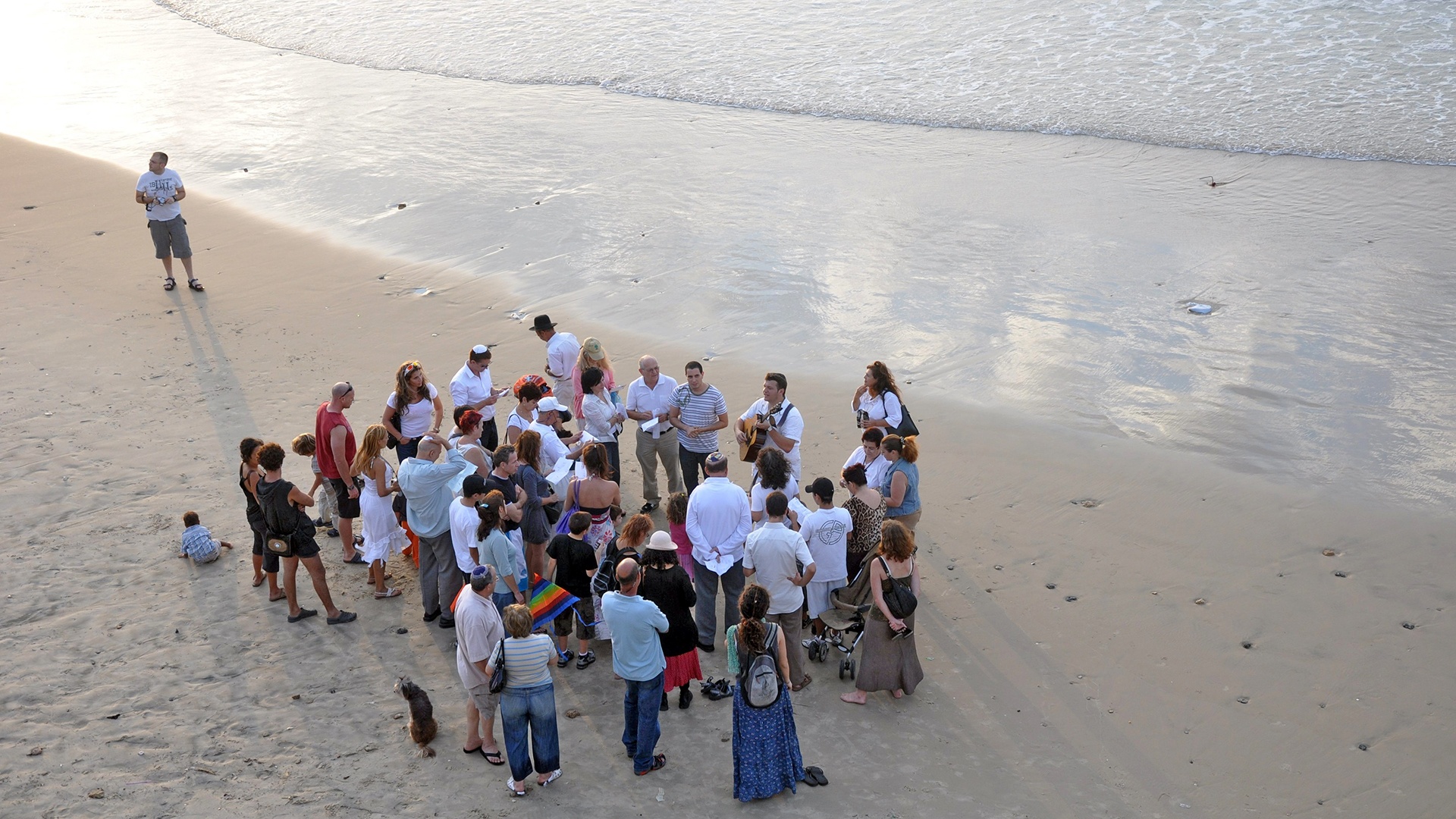 Menschen stehen in einer Gruppe am Strand von Tel Aviv