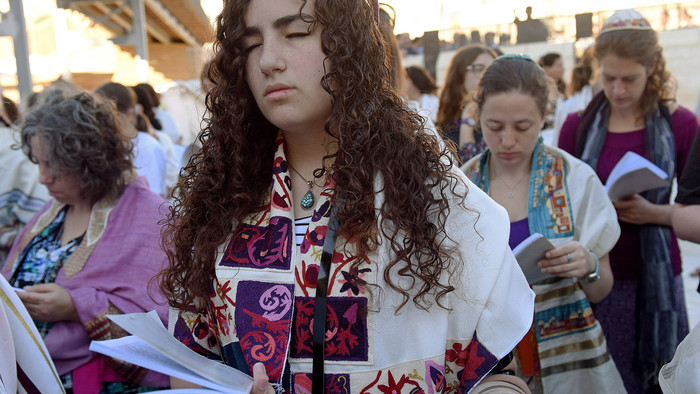 Eine junge, betende Frau trägt den jüdischen Gebetsschal Talit an der Klagemauer in Jerusalem.