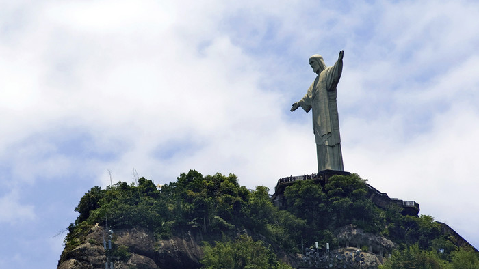 Christus-Statue in Rio de Janeiro aus hellem Beton vor blauem Himmel.