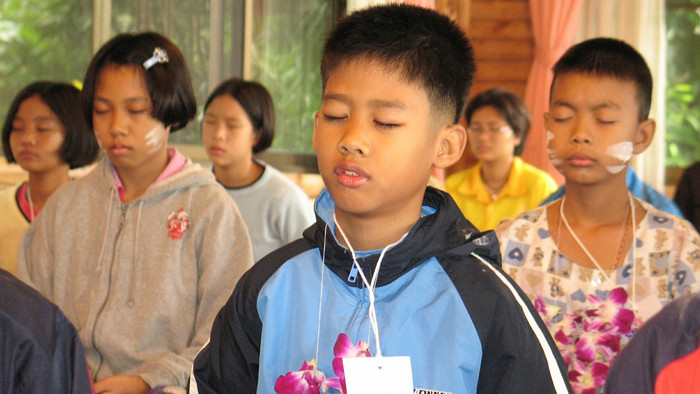 Kinder meditieren im Unterricht in Thailand