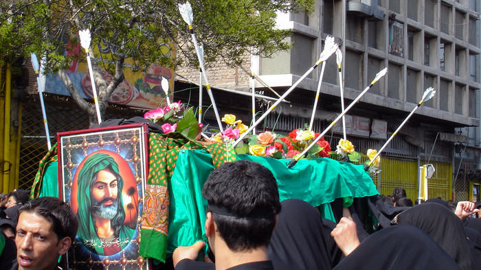 Husseins Bild mit symbolischem Sarg mit Pfeilen beim Arbain-Fest in Maschhad