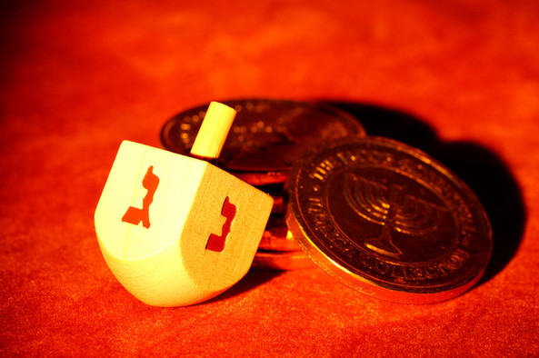 Dreidel und Münzen auf rotem Grund