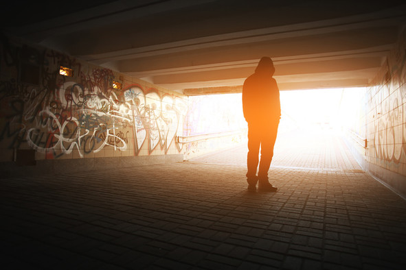 Silhouette eines jungen Mannes in einer Bahnunterführung mit Graffity.