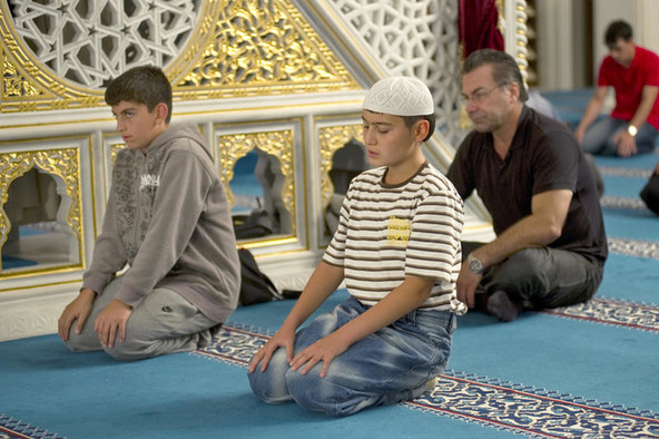 Zwei muslimische Jungen beim Gebet in einer Moschee.