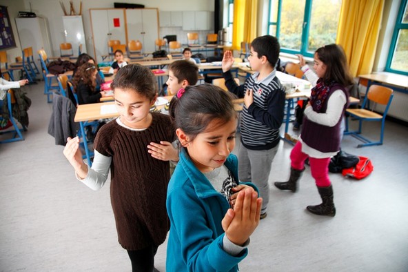 Kinder drehen im Religionsunterricht das alevitische Gebet Semah.