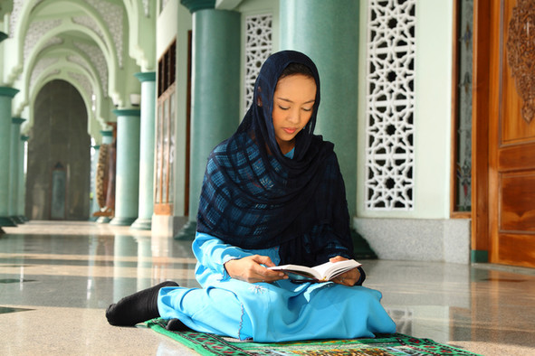 Muslimin betet auf einem Gebetsteppich