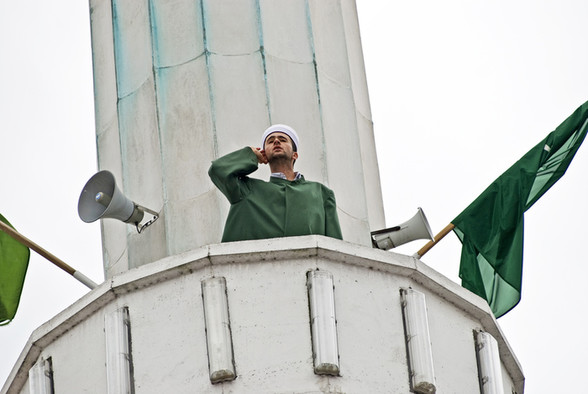 Ein muslimischer Muezzin ruft von einem Minarett aus Gläubige zum Gebet.