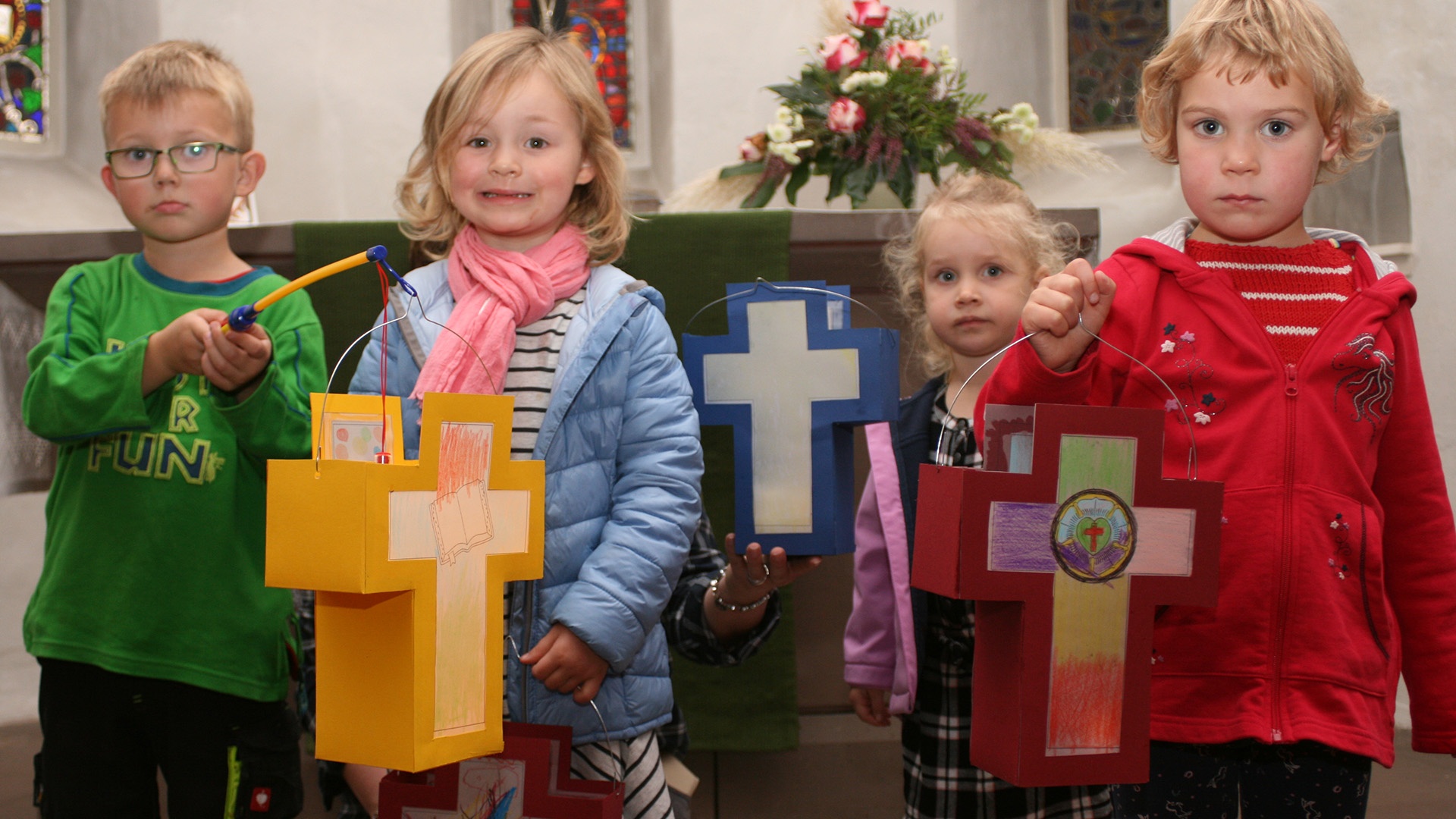 Kinder mit bunten, selbstgebastelten Lutherlaternen