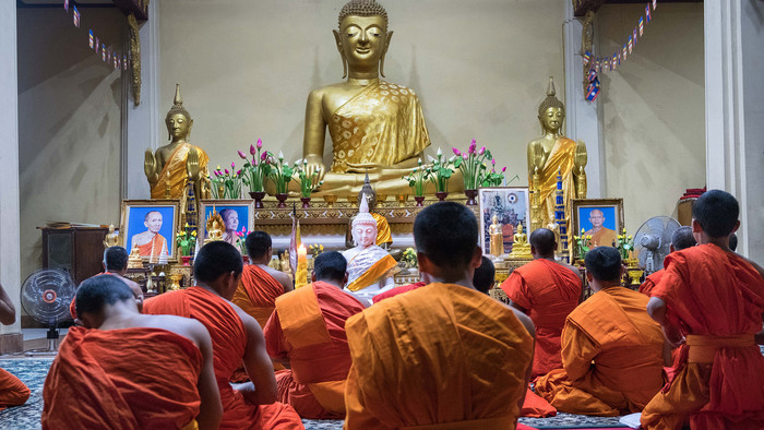 Buddhistische Mönche bei der abendlichen Meditation im That Foon Tempel in Laos.
