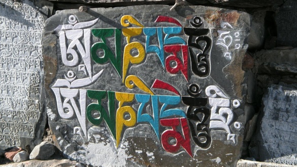 Steine mit bunten Schriftzeichen darauf im Himalaya in Nepal