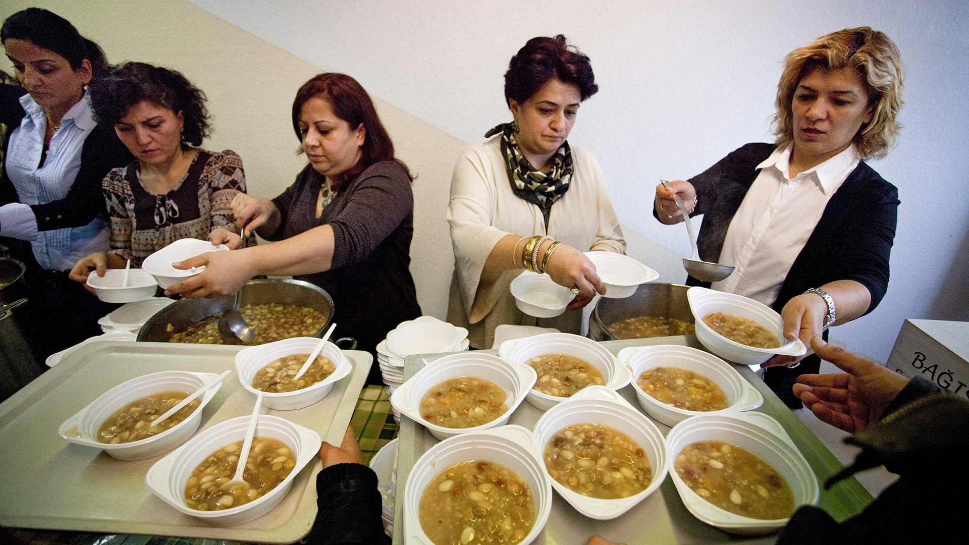 Alevitische Frauen verteilen die Asure-Suppe in kleine Schalen