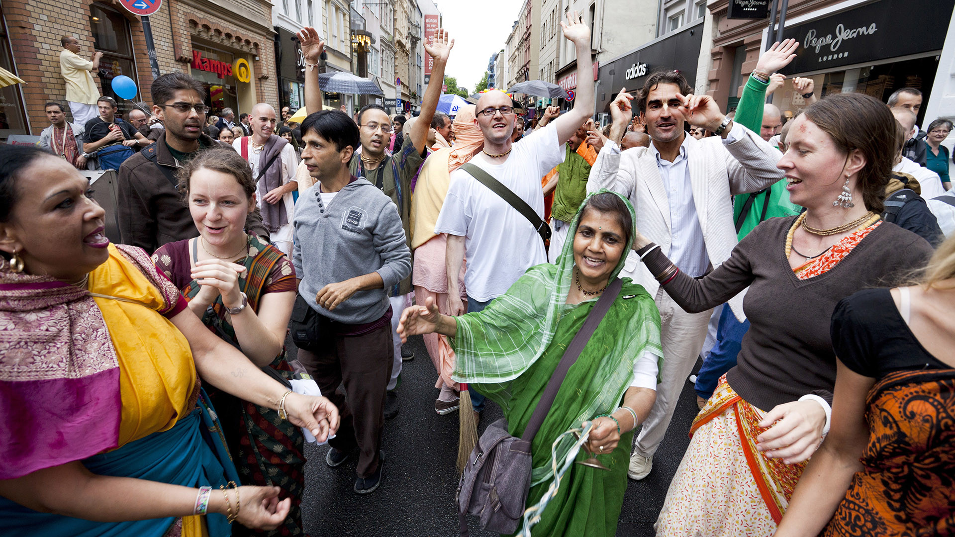 Krischna-Anhänger tanzen und singen auf einer Straße in Köln.