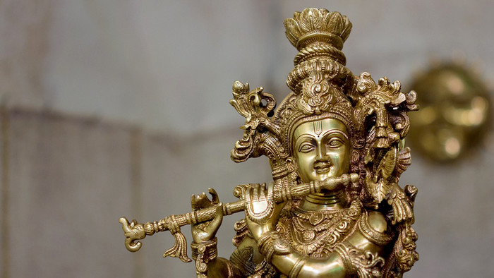 Goldene Statue von Krishna, reich verziert mit seiner Flöte in den Händen.