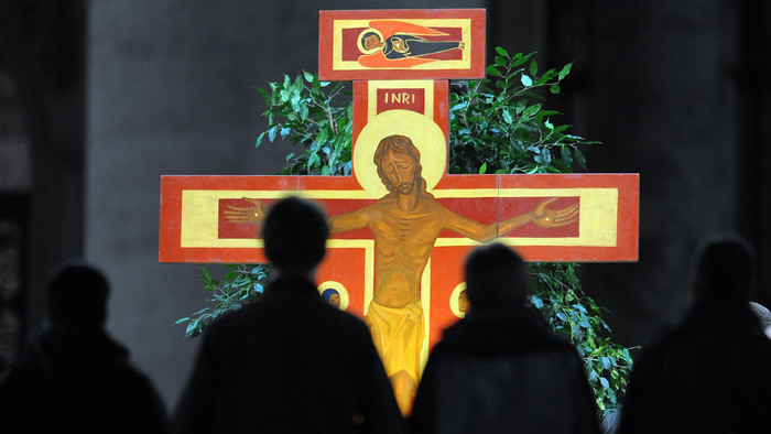 Jugendliche im Gebet vor dem Kreuz von Taizé