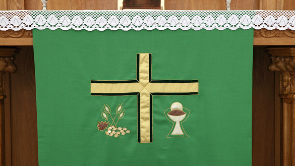 Grünes Tuch am Altar mit Kreuz in gold