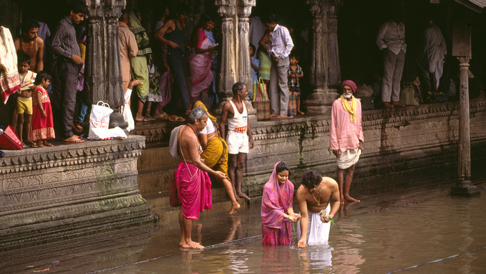 Rituelles Bad eines jungen Ehepaares in einem heiligen Teich nahe Nasik in Indien.