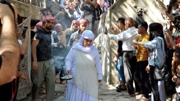 Frau trägt bei religiöser Zeremonie eine Feuerschale mit Weihrauch