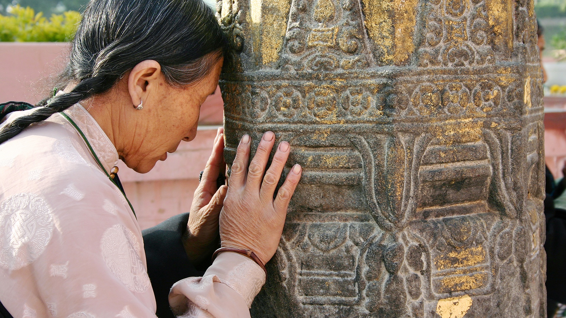 Eine Tibeterin betet am großen Tempel von Bodhgaya