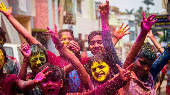 lachende Kinder zwischen buntem Pulver am Holi-Fest