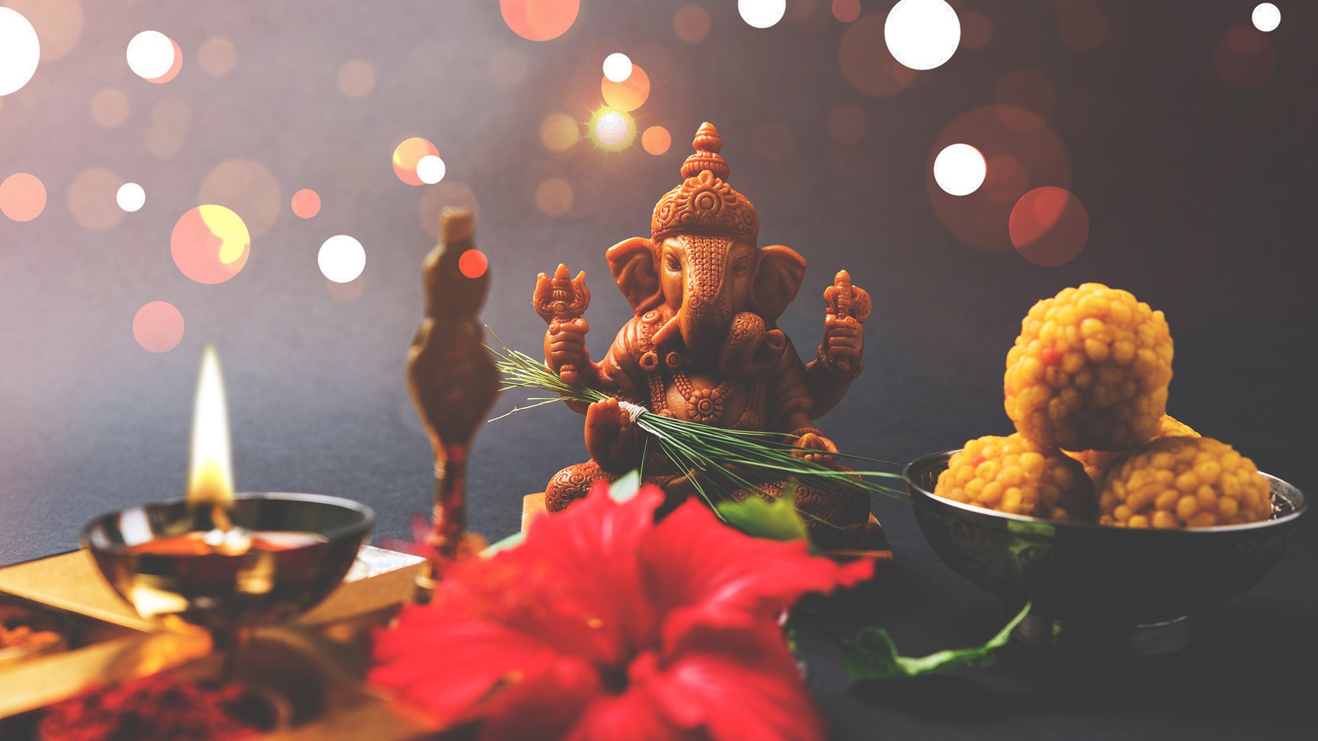 Ganesha auf einer Art Altar mit Blumen und einer Kerze