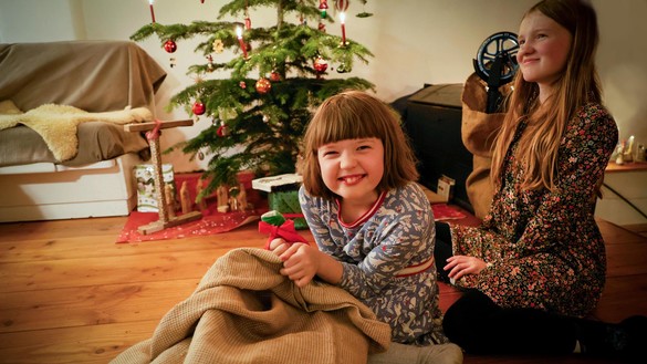 Zwei Mädchen untern Weihnachtsbaum mit Geschenken