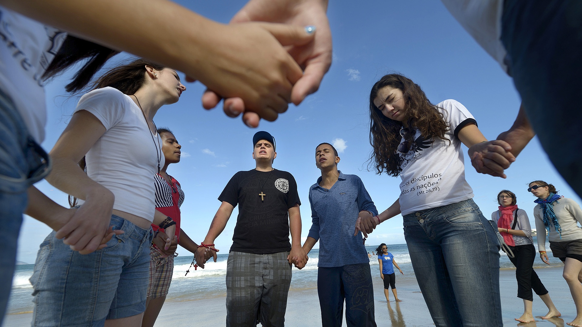 Jugendliche beten am Strand