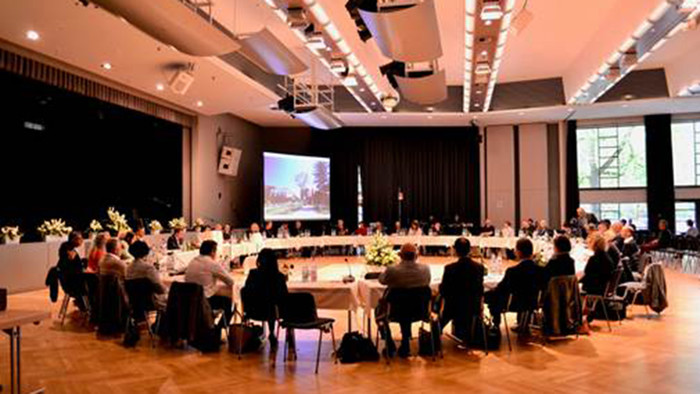 Konferenzsaal mit großem Tisch und vielen Personen darum