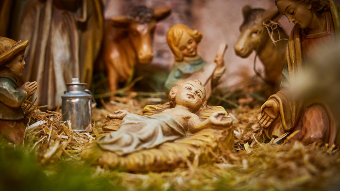 Christuskind als Krippenfigur in einem Stall.
