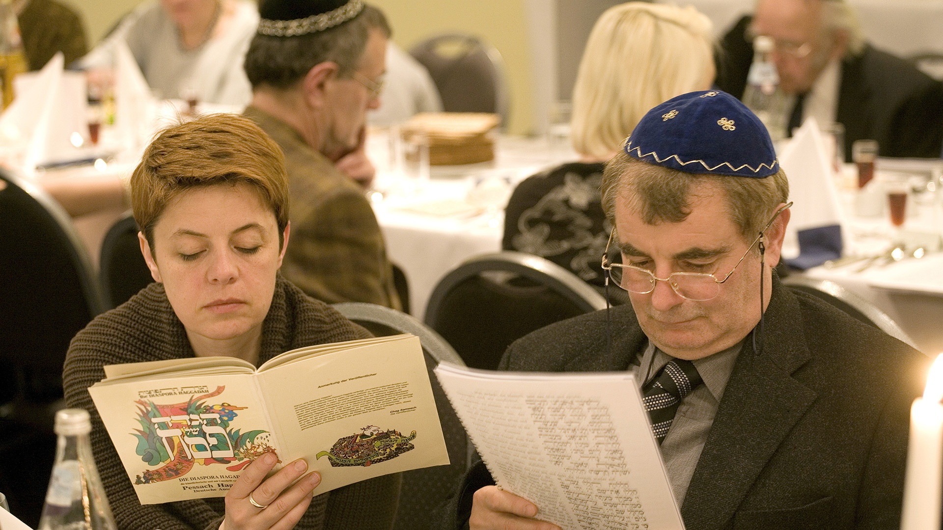 In der Haggadah lesende Juden bei einer Feier des jüdischen Pessachfestes in Berlin