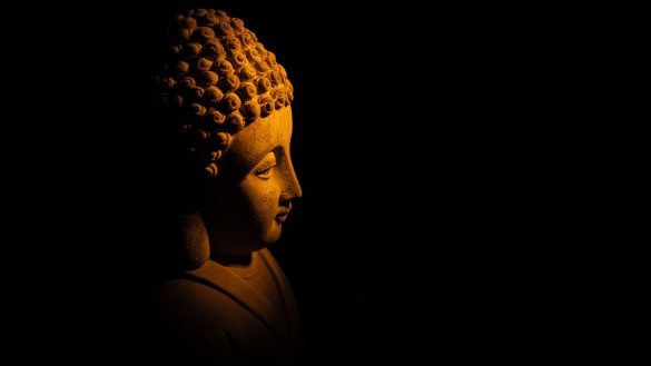 Im Dunklen angestrahlte Buddha-Statue