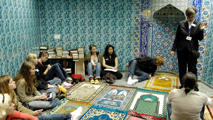 Schülerinnen im Gebetsraum mit Mihrab im Frankfurter Fluhghafen
