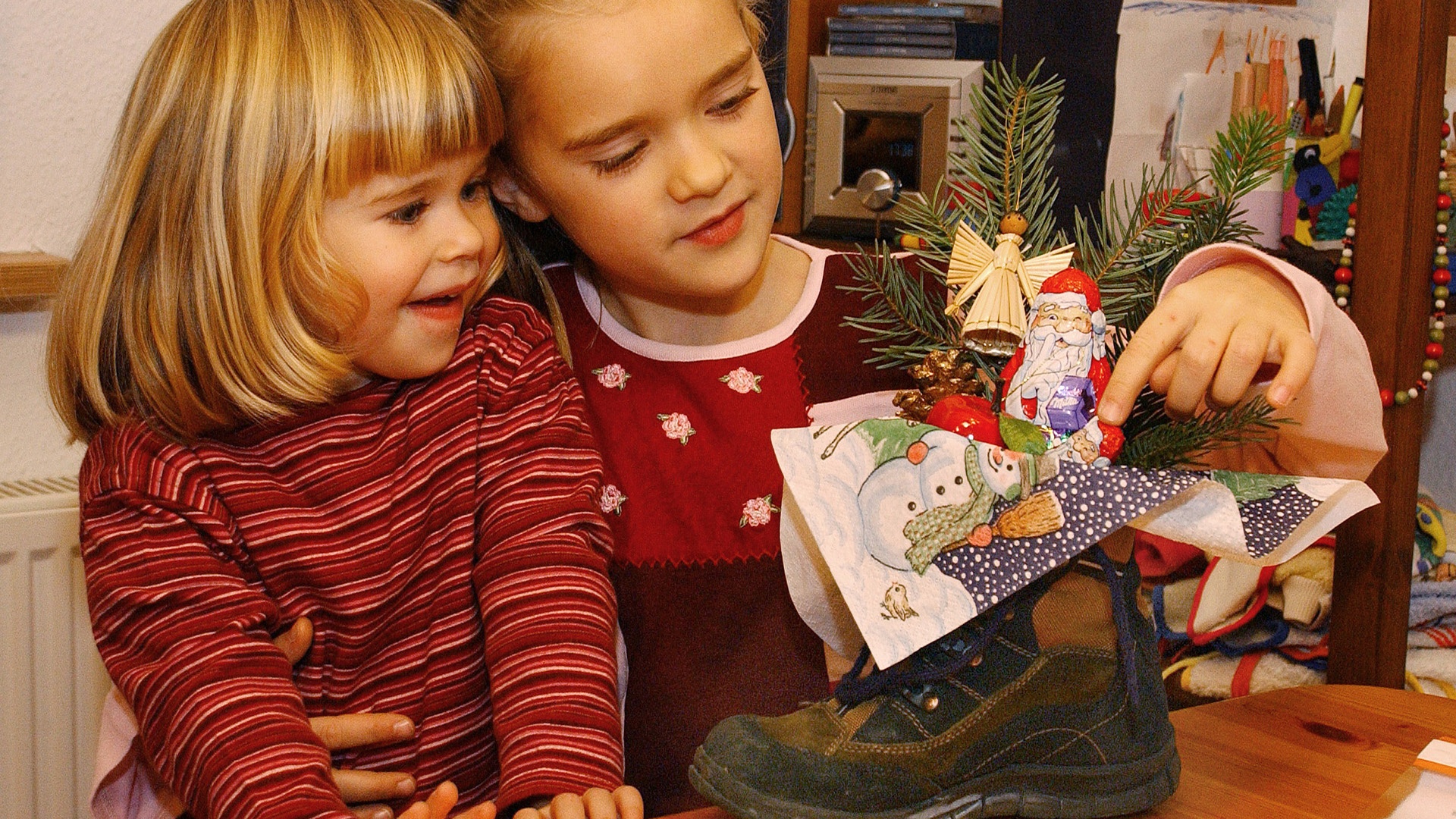 zwei Mädchen mit einem Schoko-Nikolaus in einem Schuh