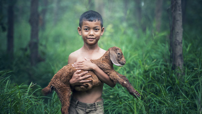 Junge mit Ziege auf dem Arm