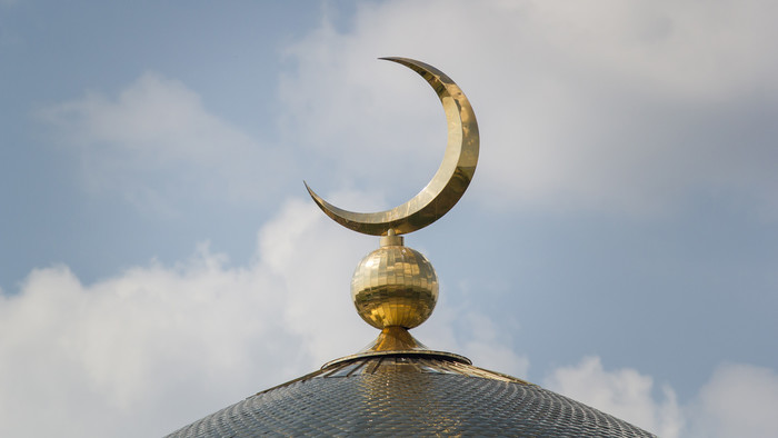 Blick auf Moschee mit einer Mondsichel auf der Spitze.