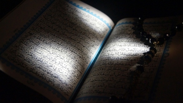 Aufgeschlagener Koran in arabisch, mit Schatten und Lichtflecken