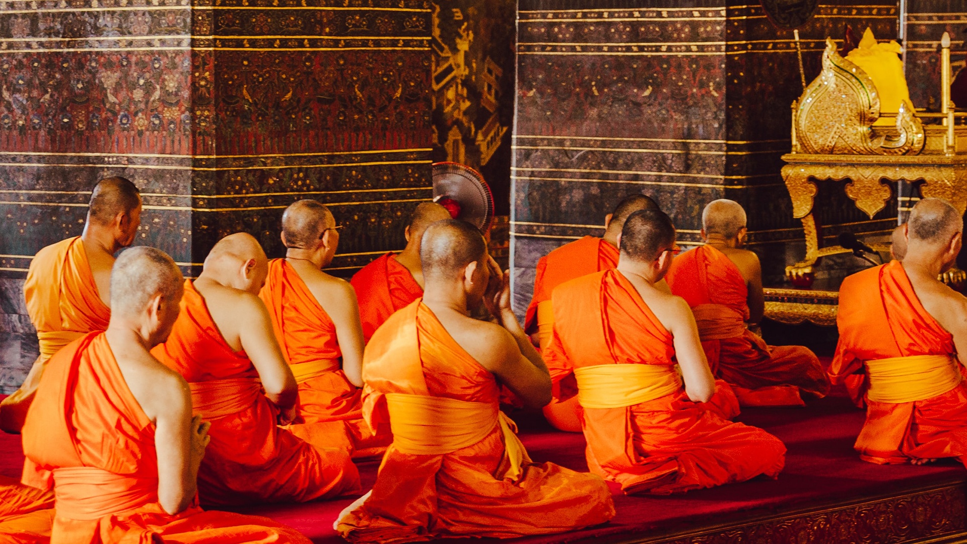 Buddhistische Mönche meditieren in orangenen Gewändern 