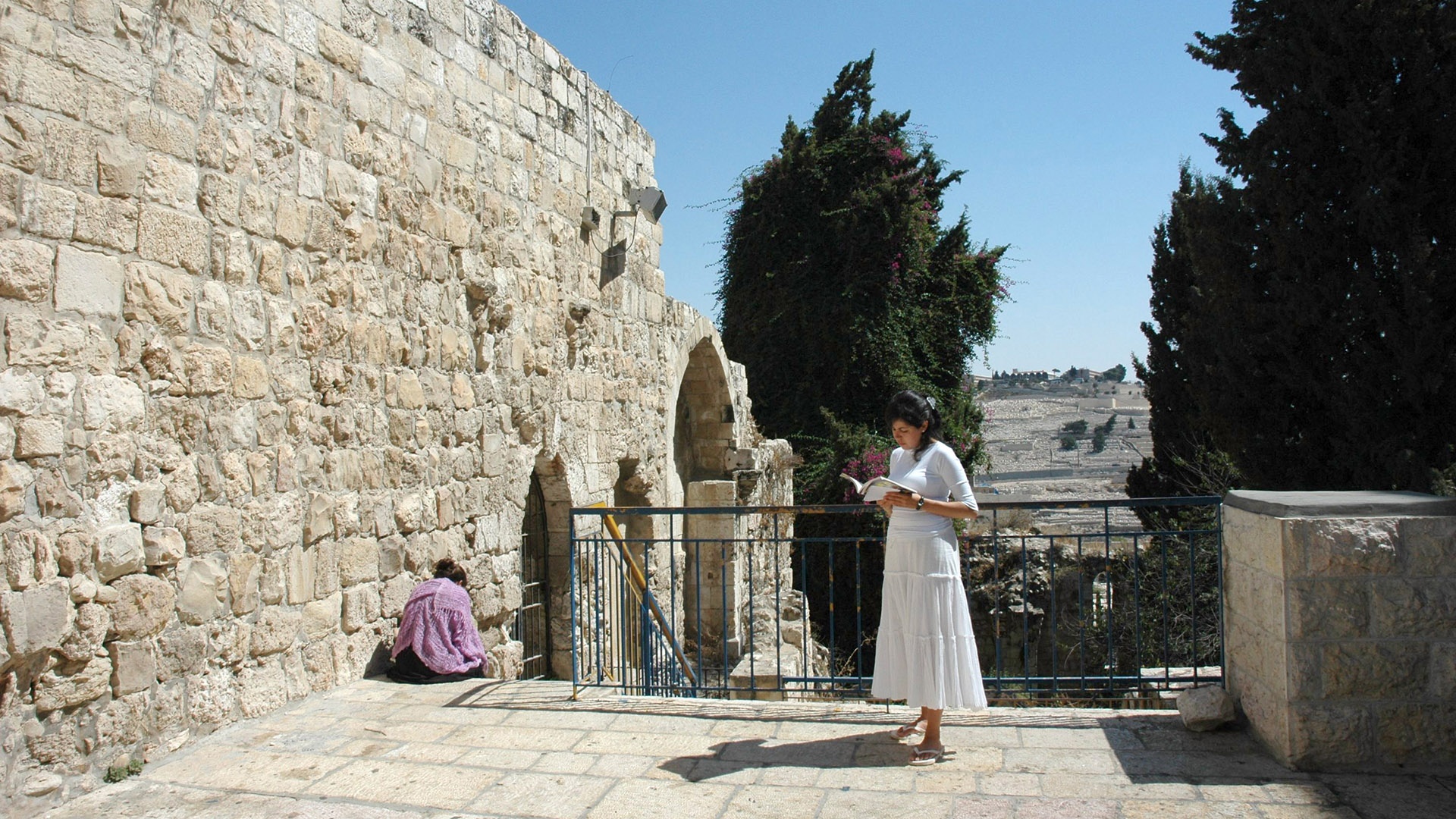 weiß gekleidete Frau betet vor einer Synagoge in Jerusalem