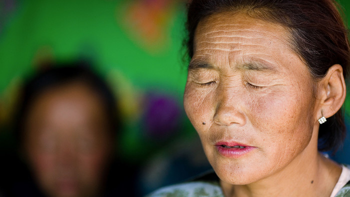 eine Frau betet mit geschlossenen Augen