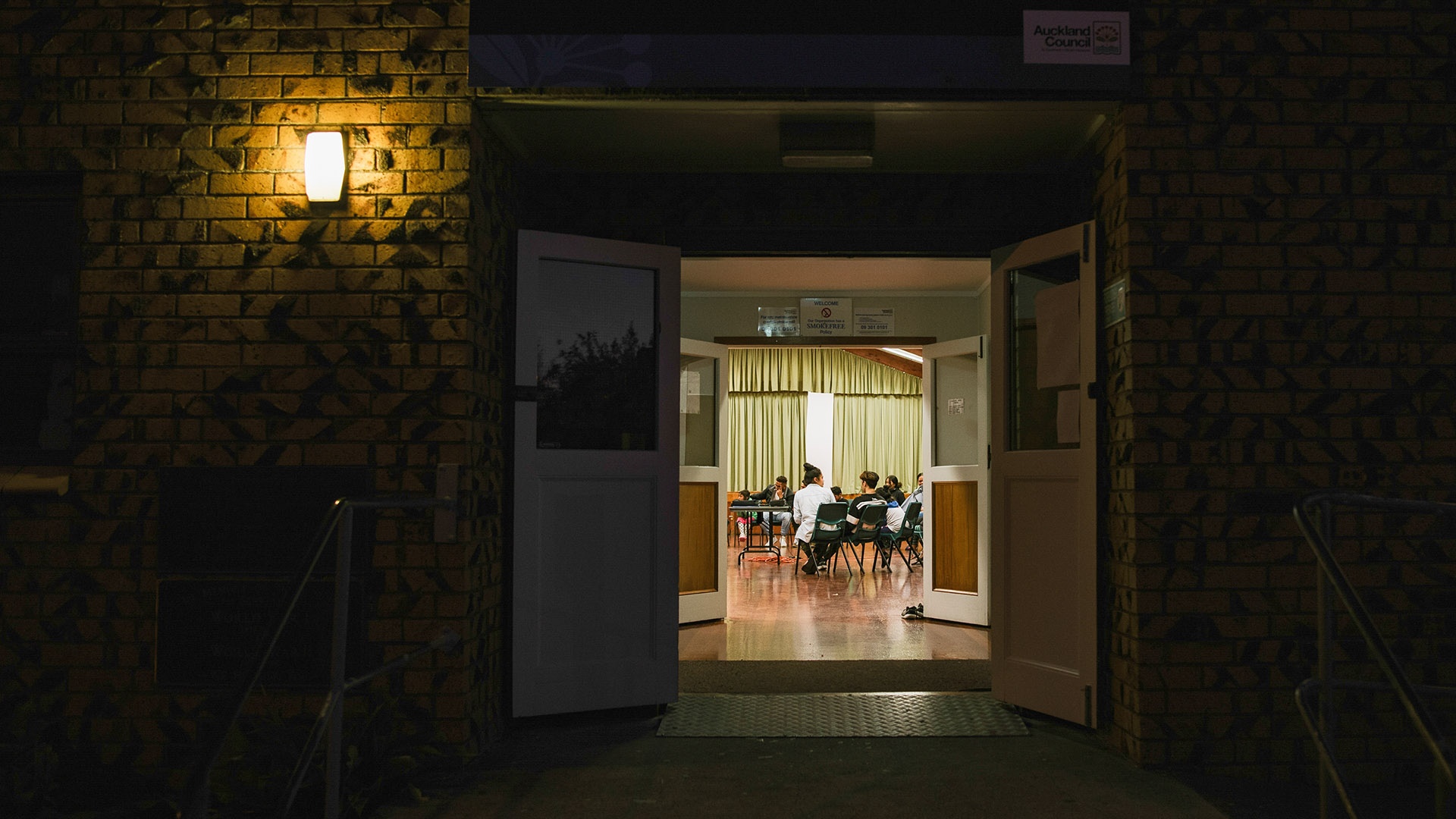 Einblick in eine bei Nacht beleuchtete Wohnung während einer Ridvan-Feier in Manurewa in Neuseeland