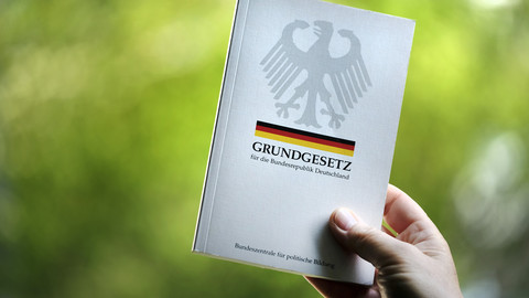 Grundgesetz für die Bundesrepublik Deutschland vor den Nationalfarben schwarz, rot, gold