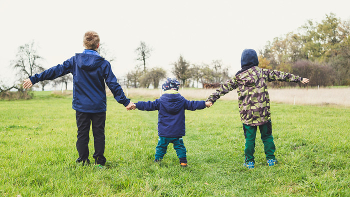 drei Kinder halten sich an den Händen