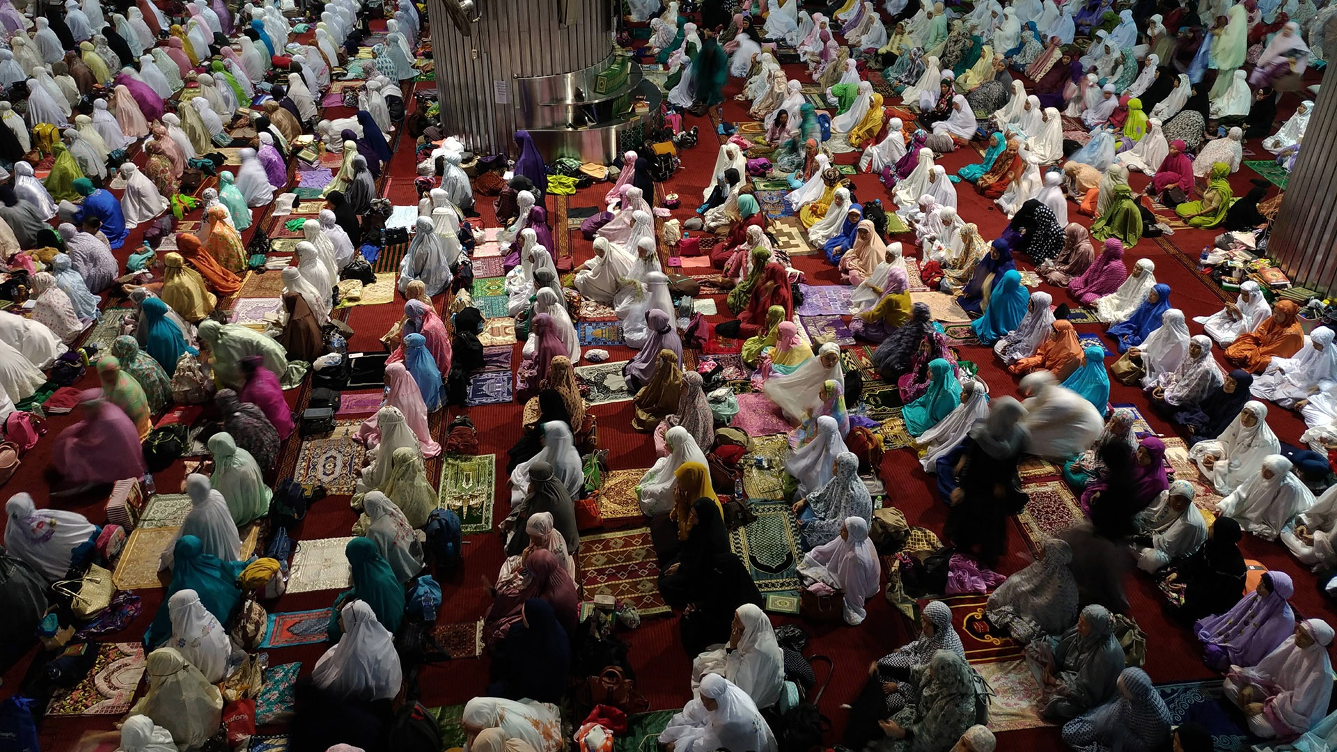 Menschenmenge betet in farbenfroher Kleidung in Jakarta in Indonesien