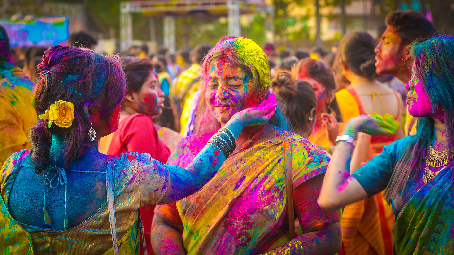 Freundesgruppe spielt mit pulvrigen Farben in Holi in Kolkata, India.