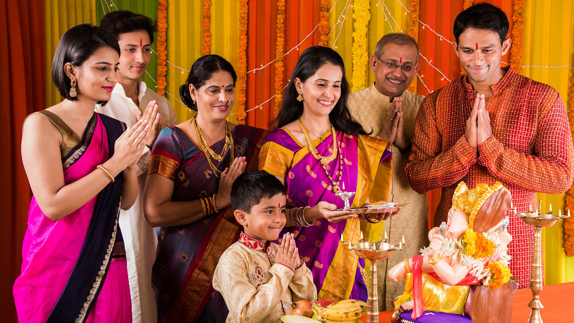 Indische Familie betet zu Hause an Ganesha Chaturthi